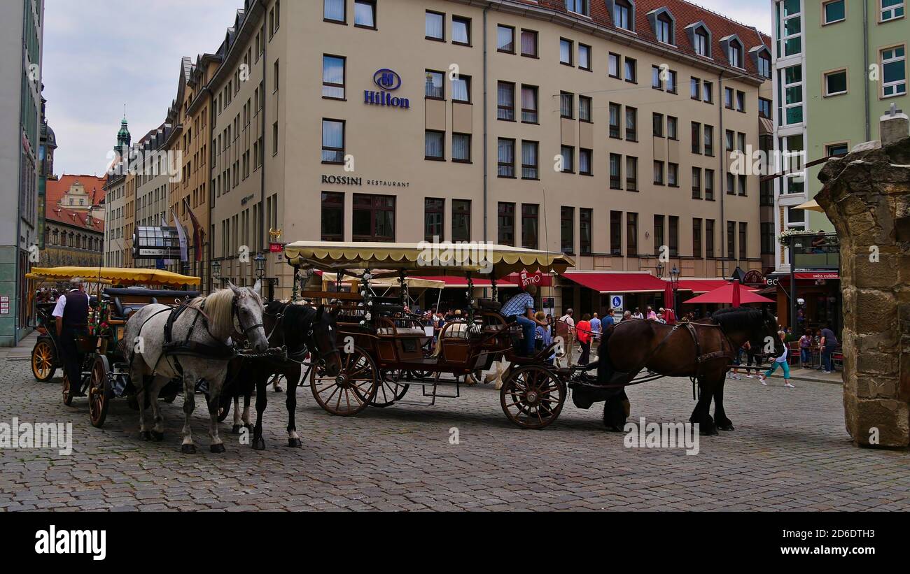 Dresda, Germania - 06/16/2018: Cavallo e cart in piedi su strada acciottolata nel centro storico di Dresda di fronte all'hotel Hilton. Foto Stock