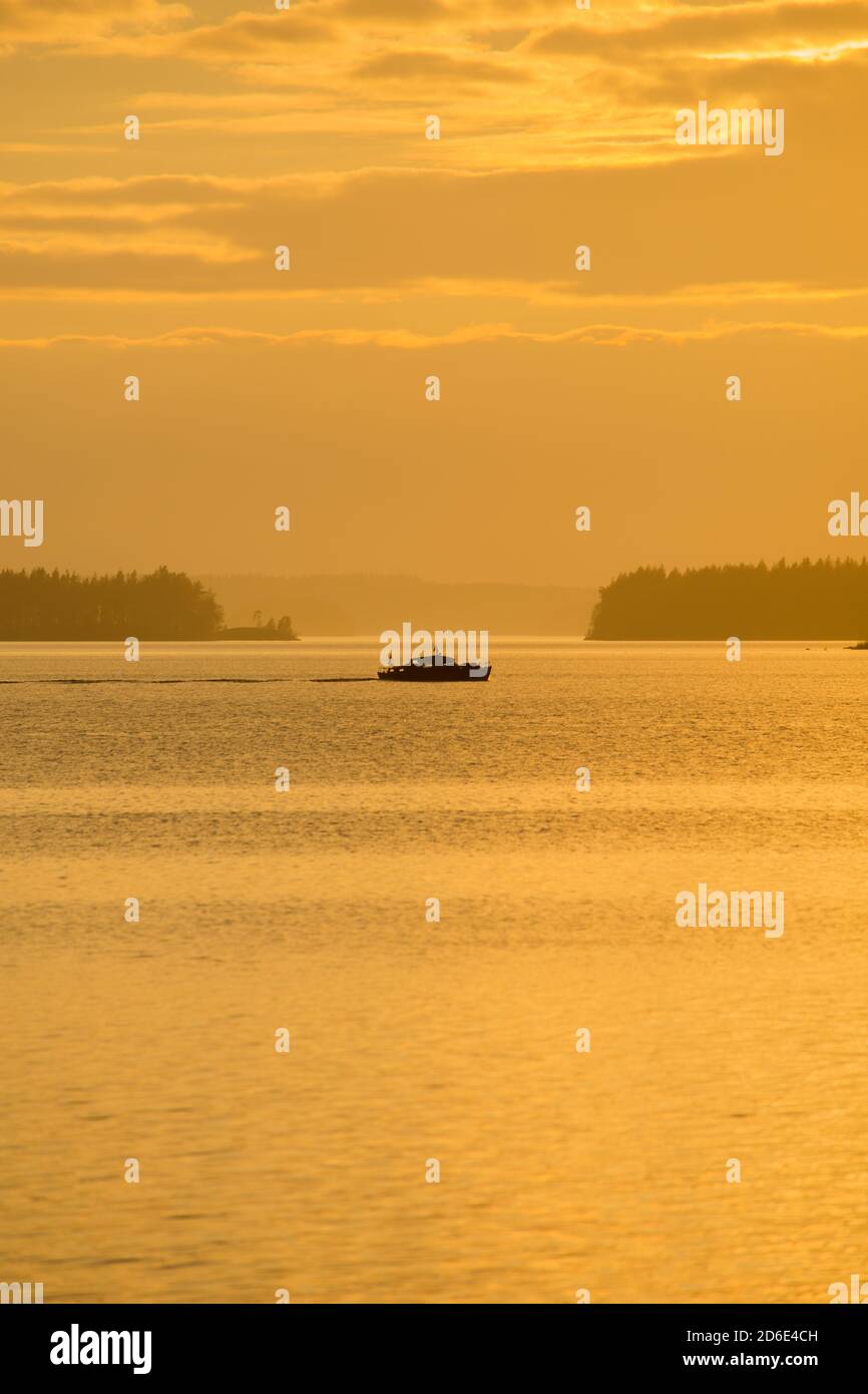 Silhouette della barca contro l'orizzonte, colori del tramonto, Finlandia Foto Stock