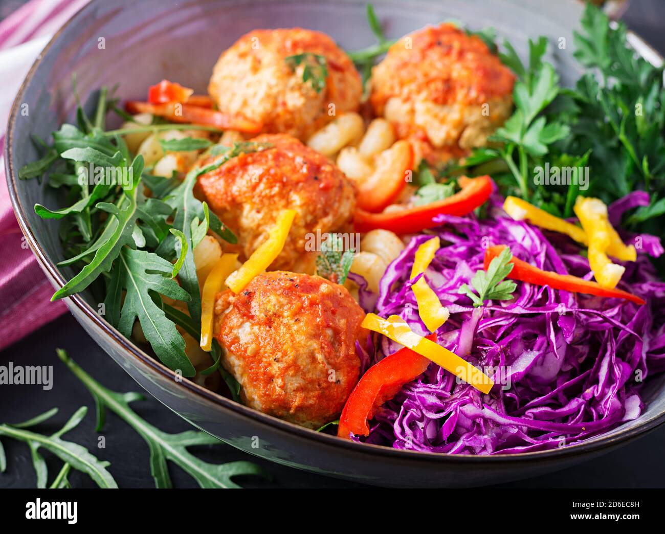 Pasta italiana. CAVATAPPI con polpette e insalata su sfondo scuro. Cena. Concetto di cibo lento Foto Stock