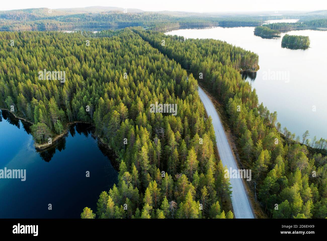 Vista aerea di una strada tra una foresta e laghi in estate nel nord della Finlandia. Foto Stock