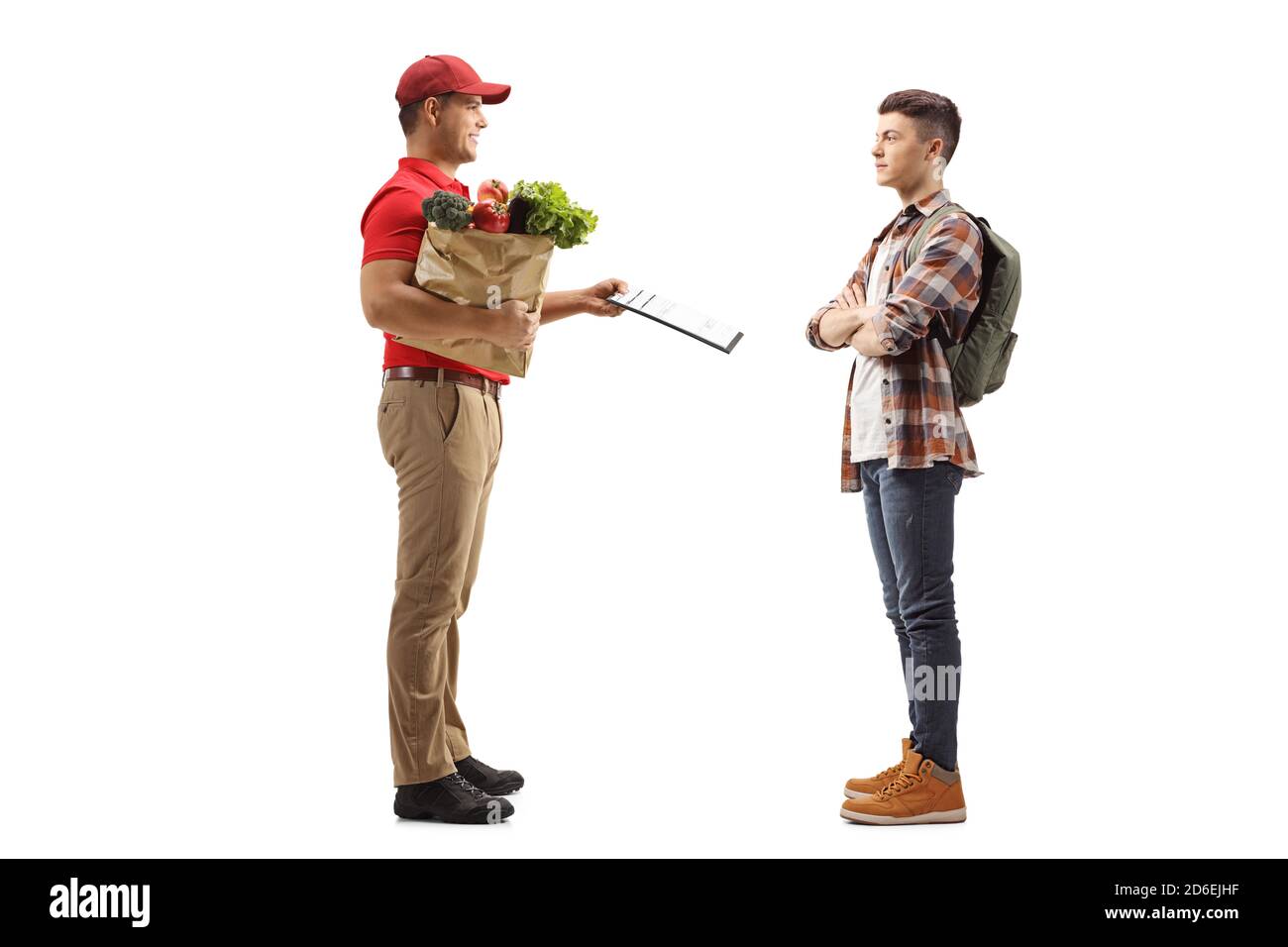 Foto di profilo a lunghezza intera di un uomo che consegna generi alimentari e. dare un documento ad un giovane studente maschile isolato sopra sfondo bianco Foto Stock
