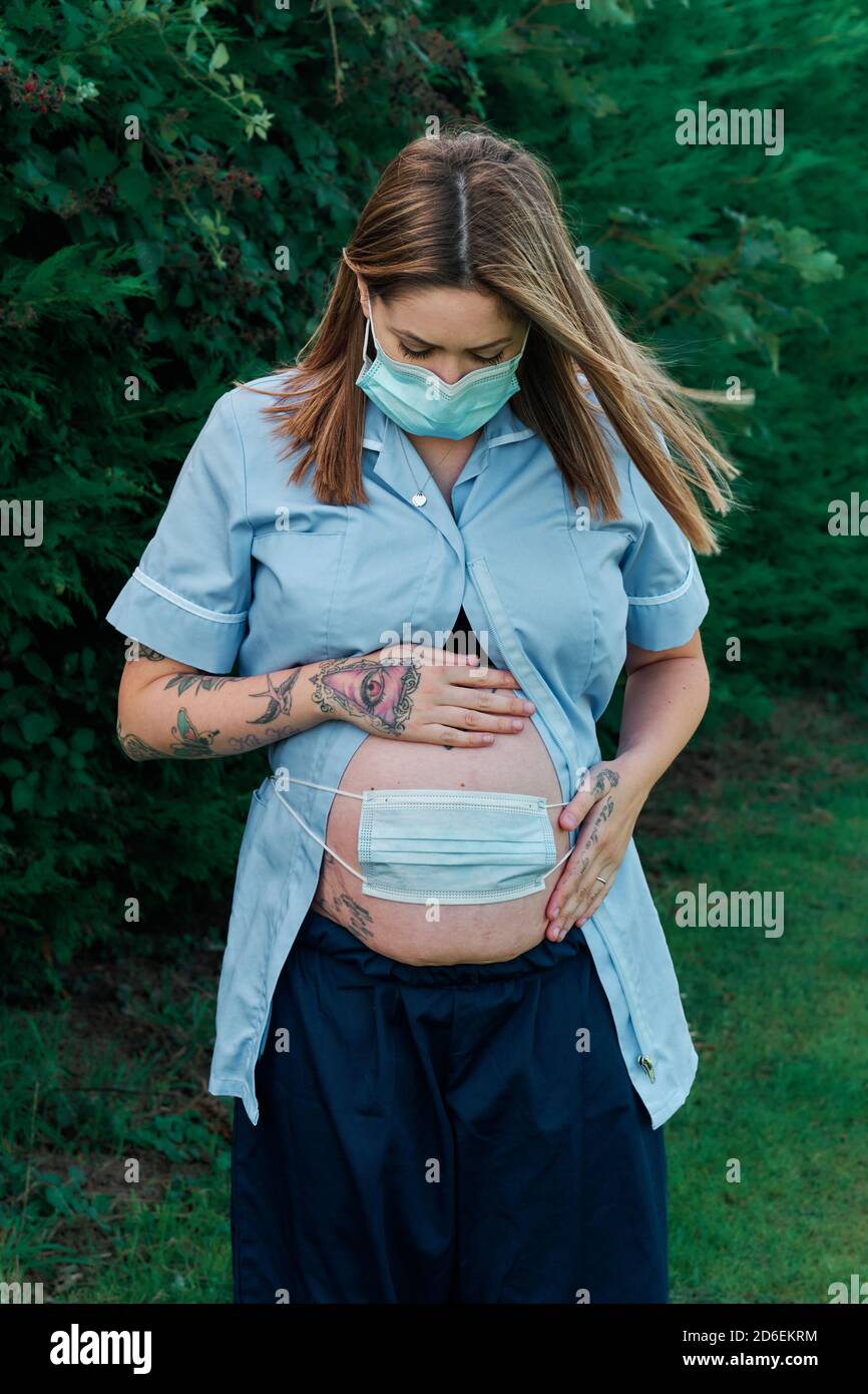 Il lavoratore di cura incinta ha preoccupato circa il futuro mentre lavora durante la pandemia di Coronavirus del Covid 19 2020. Foto Stock