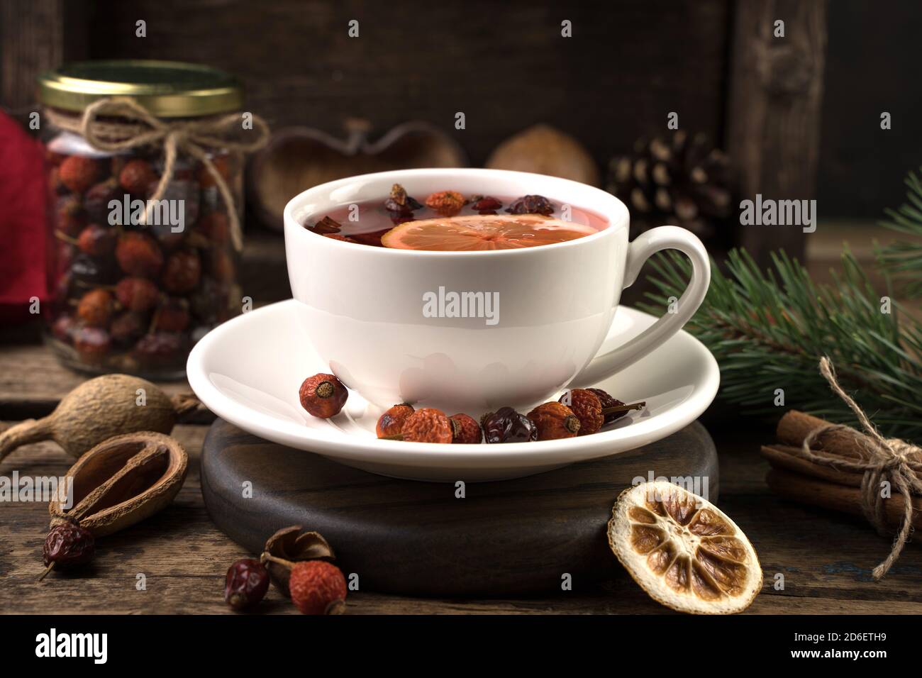 Tè con cannella e limone in una tazza bianca da vicino - su uno sfondo scuro. Foto Stock
