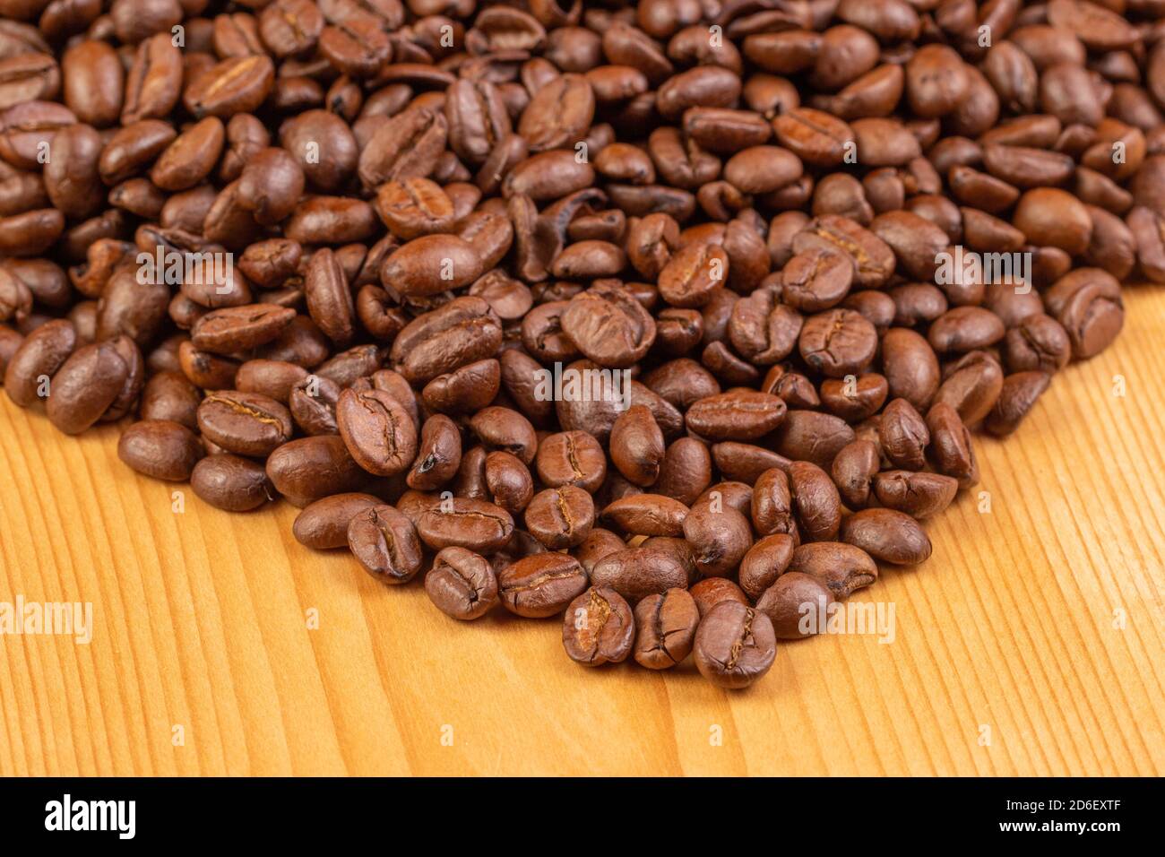 Closeup di chicchi di caffè arrostiti su sfondo di legno. Macro. Foto Stock