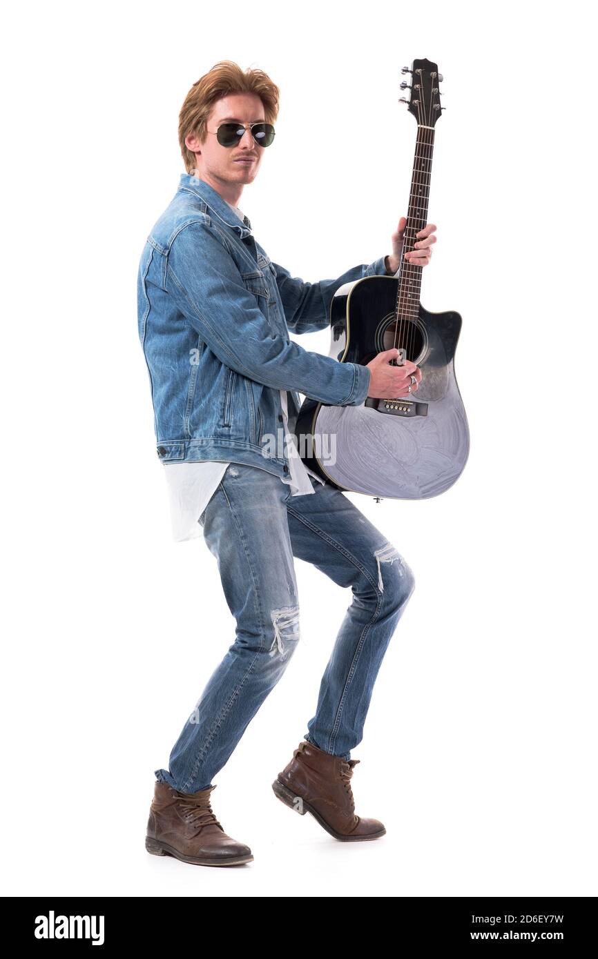 Un giovane e talentuoso chitarrista di stile che suona la chitarra tenendola in verticale. Corpo intero isolato su sfondo bianco. Foto Stock