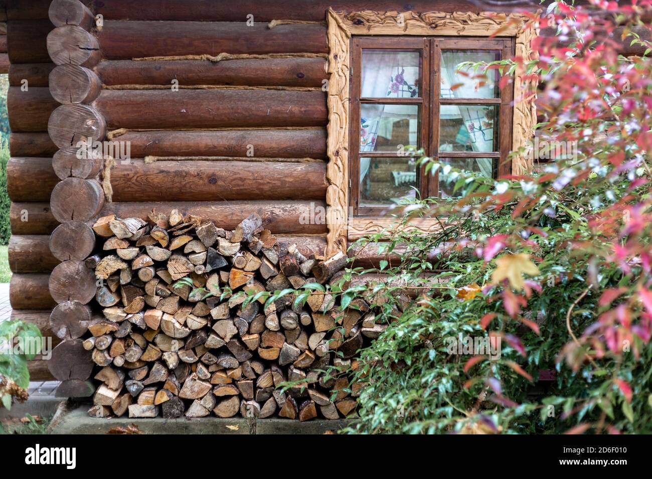 Lotti di legna da ardere accatastati contro un muro di legno Foto Stock