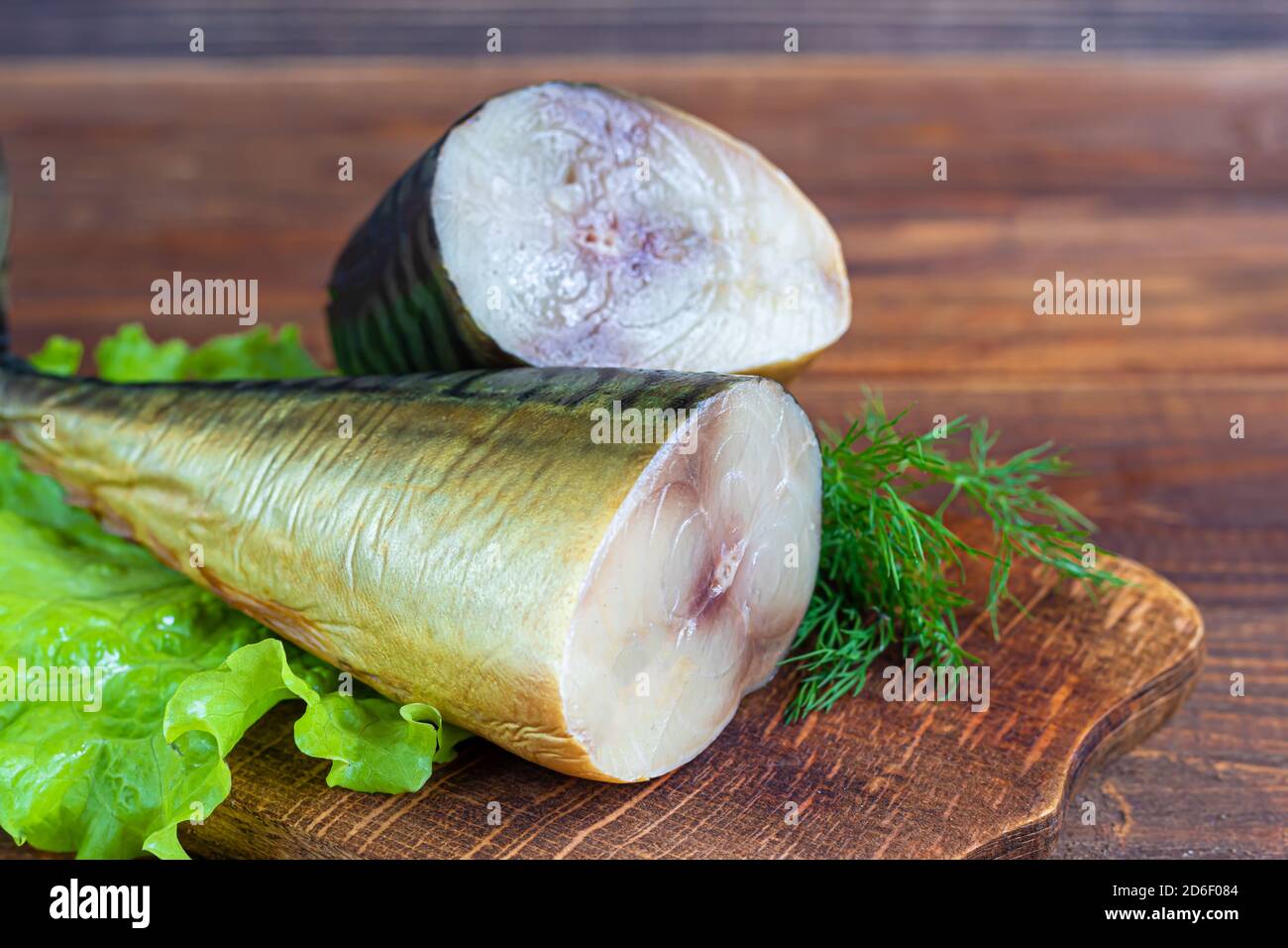 Sgombro affumicato. Filetto di pesce fresco con ingredienti culinari, erbe e limone su sfondo nero, vista laterale. Spazio di copia. Foto Stock