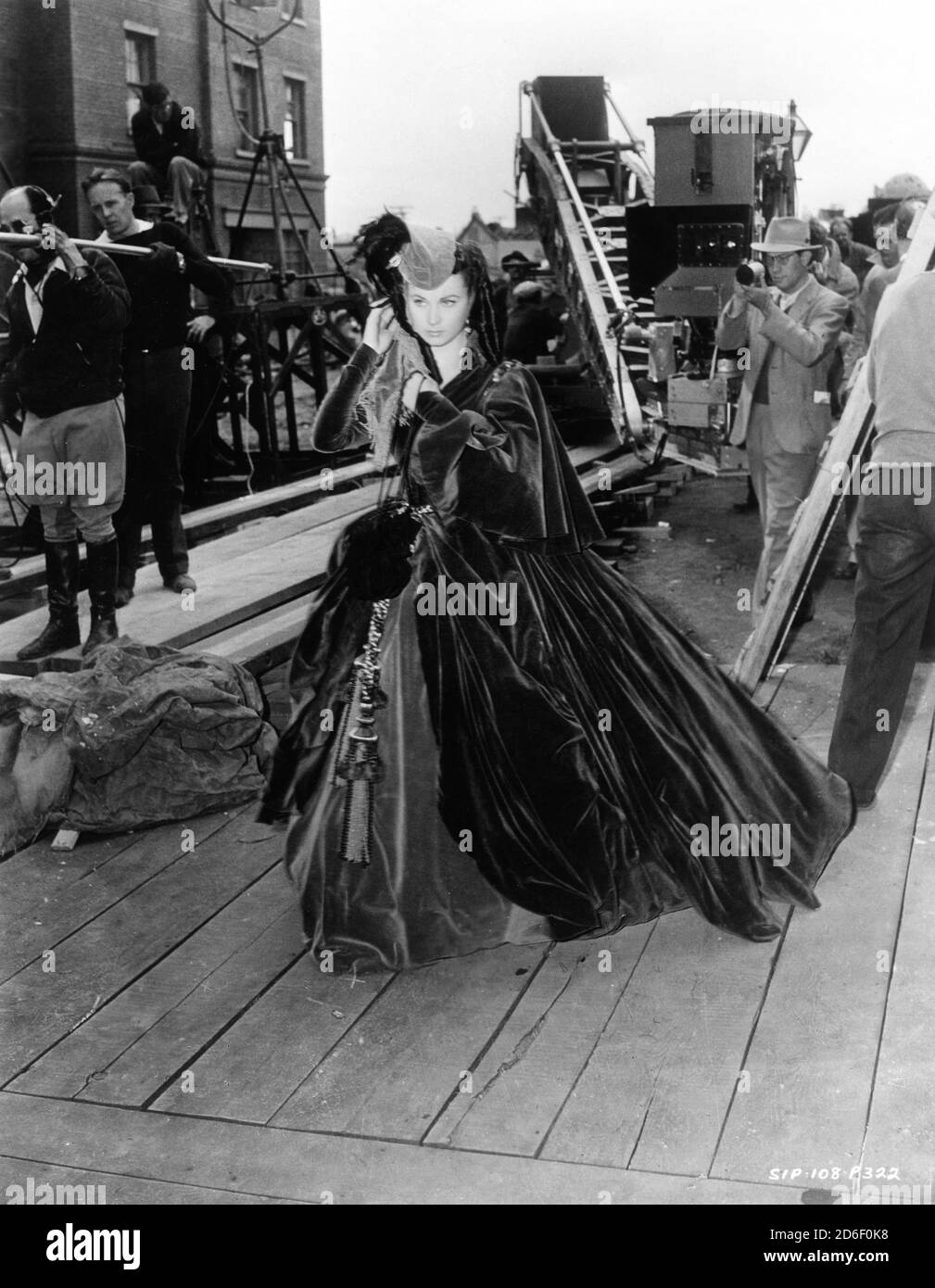 VIVIEN LEIGH cantò con Movie Crew su Atlanta Set indossare Tenda vestito durante le riprese di GONE WITH THE WIND 1939 regista VICTOR FLEMING romanzo Margaret Mitchell musica Max Steiner Costumi Walter Plunkett produttore David O. Selznick Selznick International Pictures / Metro Goldwyn Mayer Foto Stock
