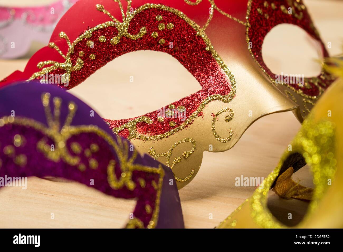 Alcune maschere di carnevale colorate su un tavolo di legno Foto Stock