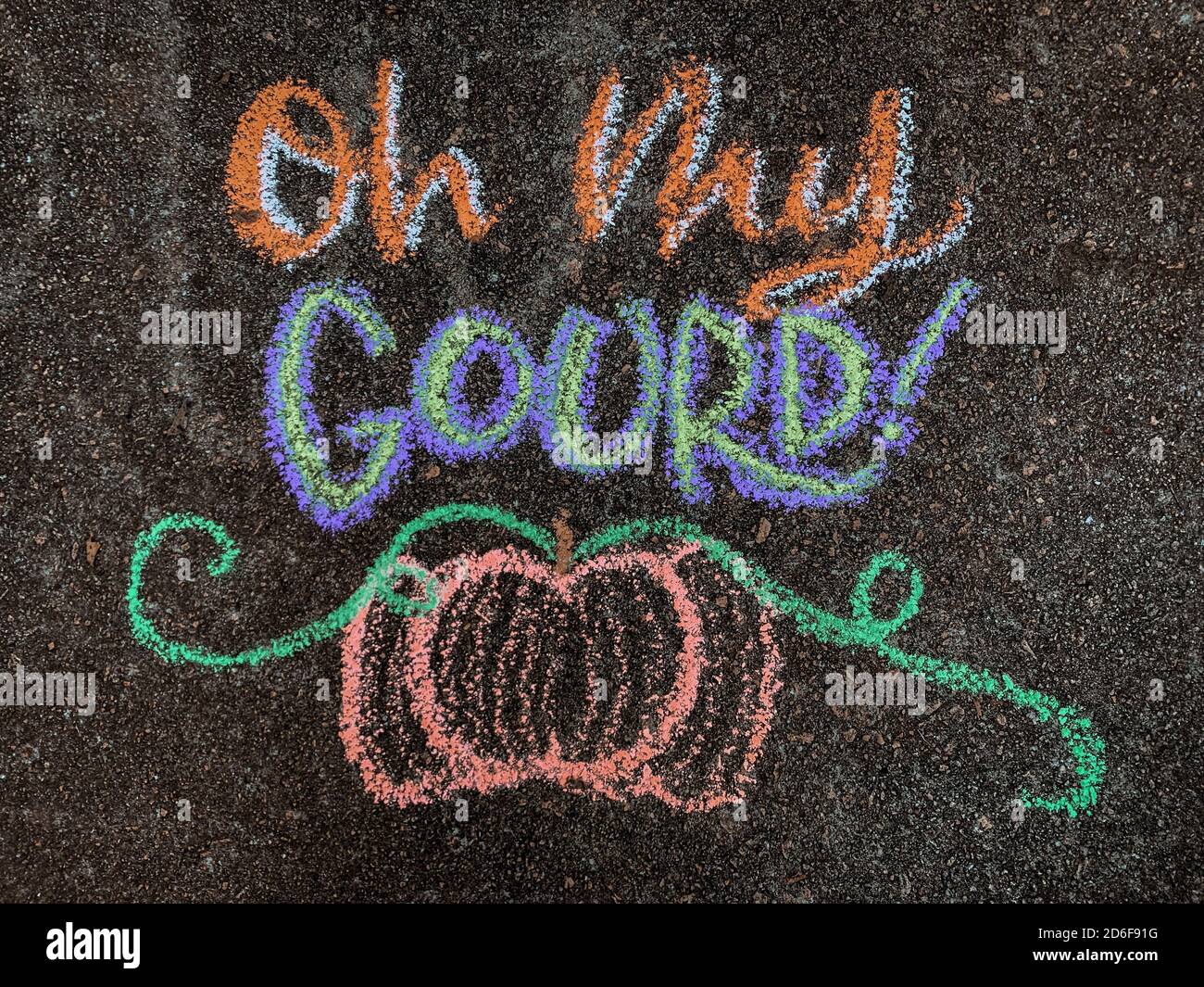 Coloratissima arte gessata autunnale su un vialetto che dice: "OH mio gourd!" con una zucca sotto. Foto Stock