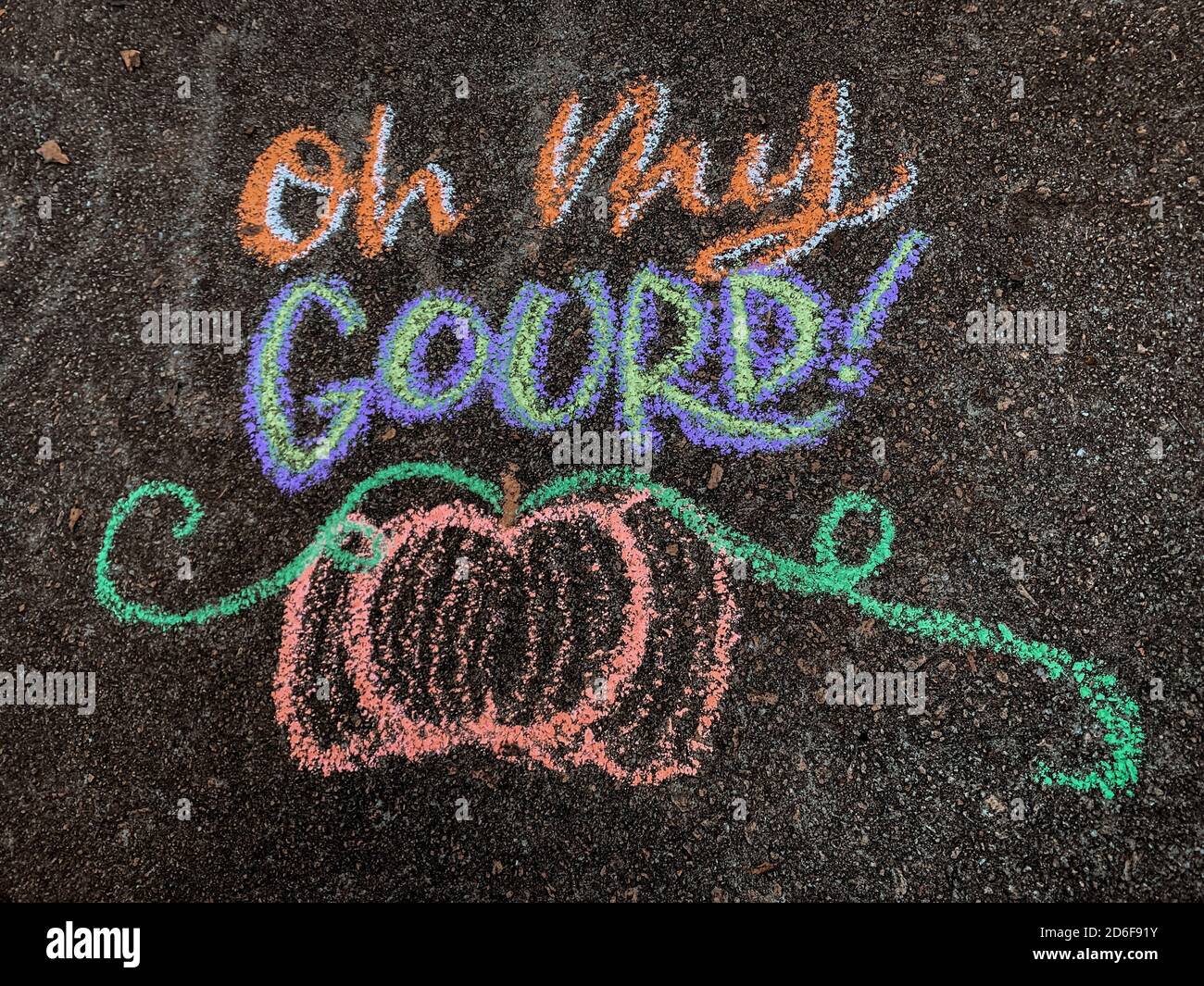 Coloratissima arte gessata autunnale su un vialetto che dice: "OH mio gourd!" con una zucca sotto. Foto Stock