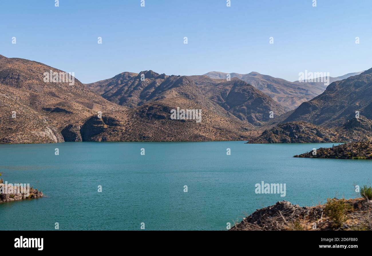 Vicuna, Cile - 7 dicembre 2008: Paesaggio di montagne brune e acque azzurre Lago Embalse Puclaro in Andes lungo la strada statale 41 sotto il cielo blu profondo. Foto Stock