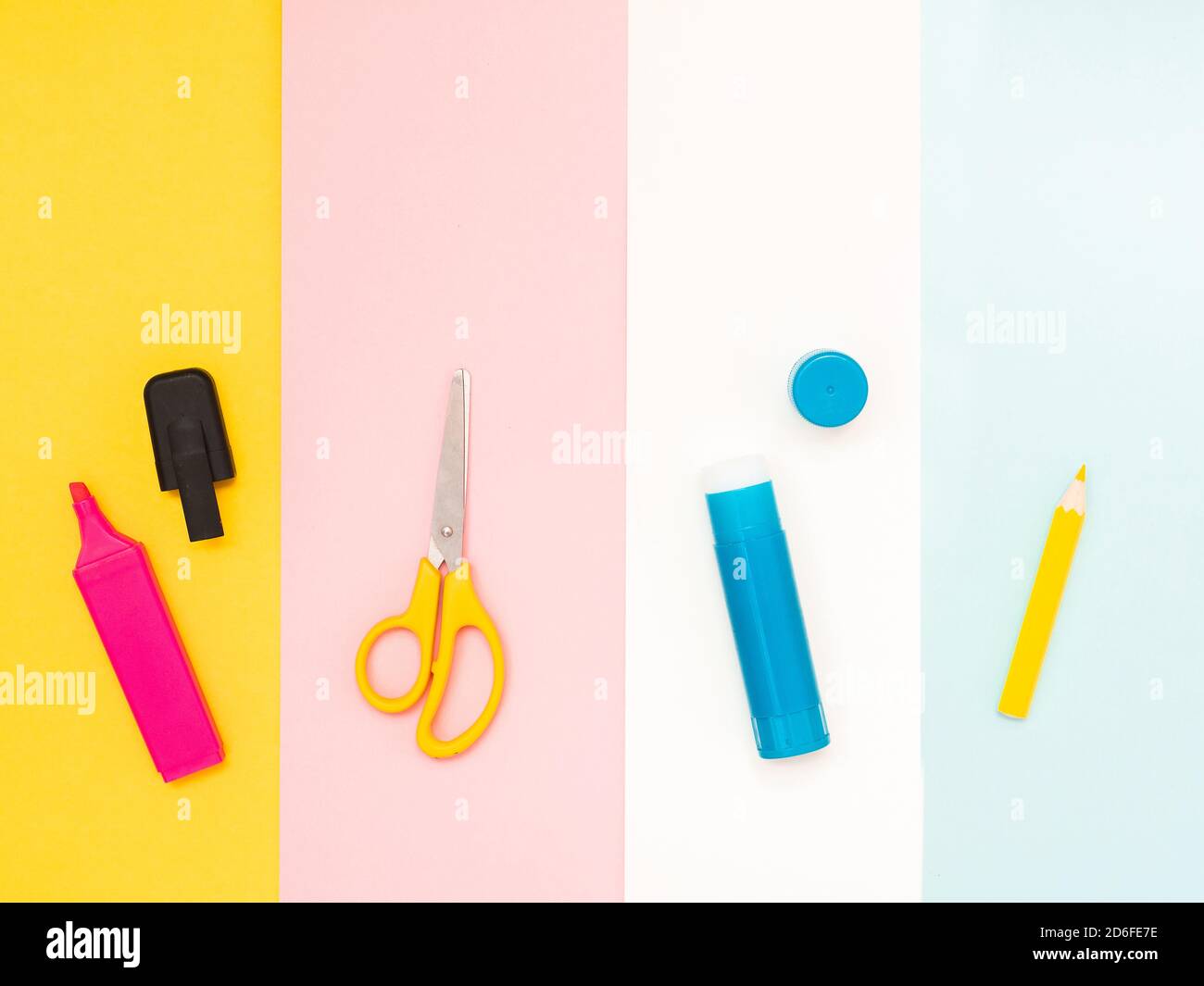 Ritorno a scuola, concetto di istruzione. Strumenti scolastici multicolore; pennarello rosa, forbici gialle; colla blu; matite bianche isolate su diversi colori sul retro Foto Stock