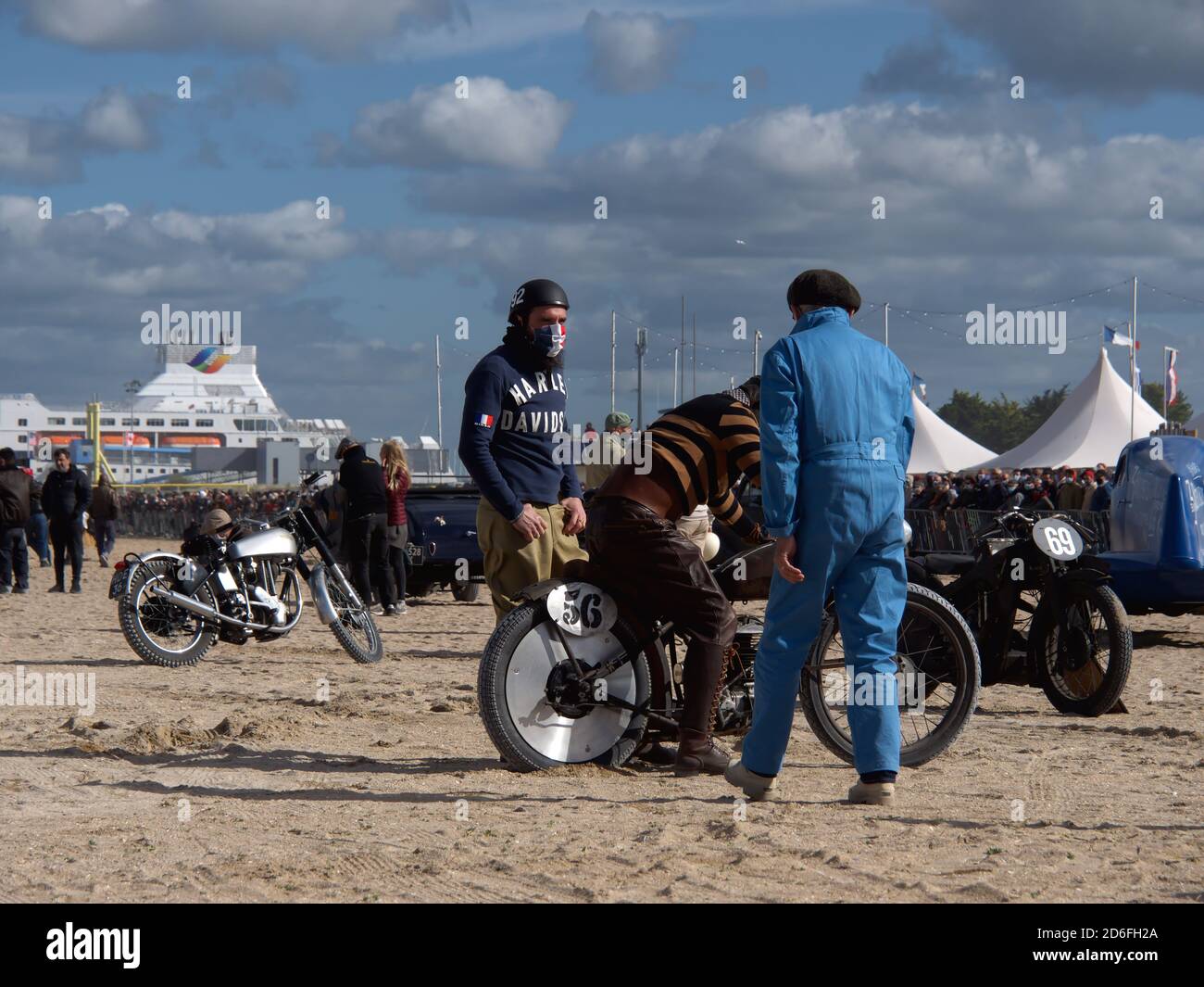 Normandy Beach Race sulla spiaggia di Ouistreham, vecchio Harley Davidson guasto motociclistico e piloti che si aiutano a vicenda, vecchi abiti retrò Foto Stock