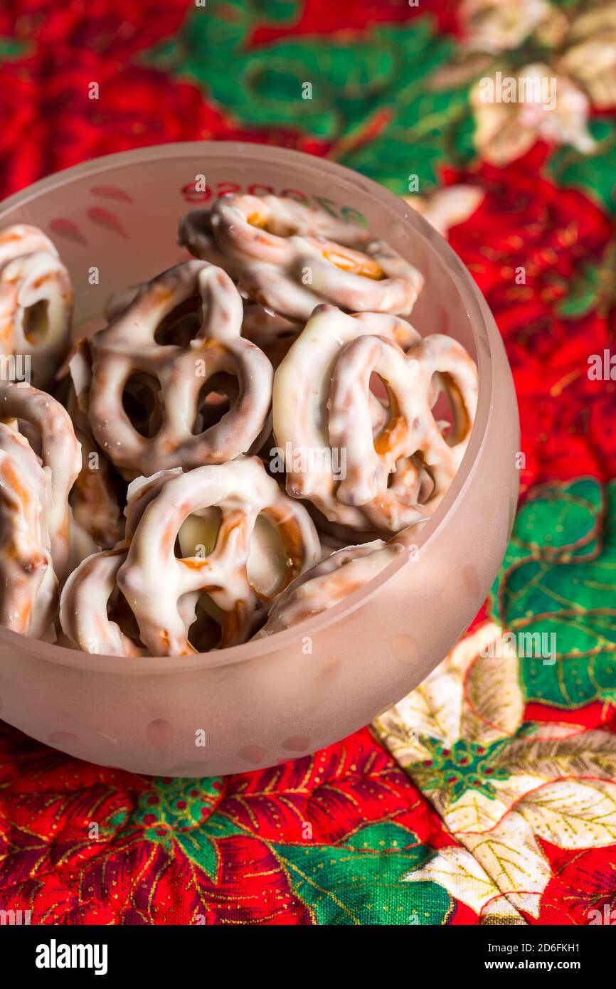 Pretzel di cioccolato bianco in ciotola sul runner del tavolo di Natale Foto Stock