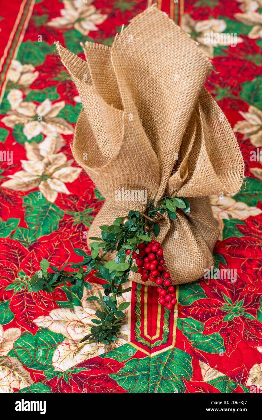 Torta regalo di Natale avvolta su corridore del tavolo di Natale Foto Stock