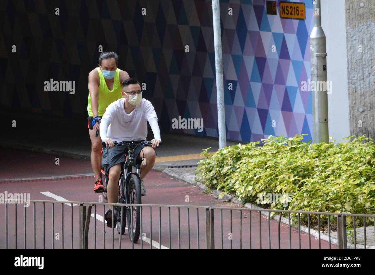 Uomini in bicicletta su una pista ciclabile separata di grado a Yuen Long, Hong Kong Foto Stock