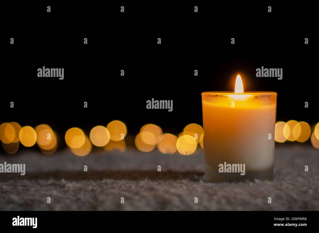 Luci a candela nel buio con luci bokeh dorate per Natale e Capodanno concetto. Foto Stock