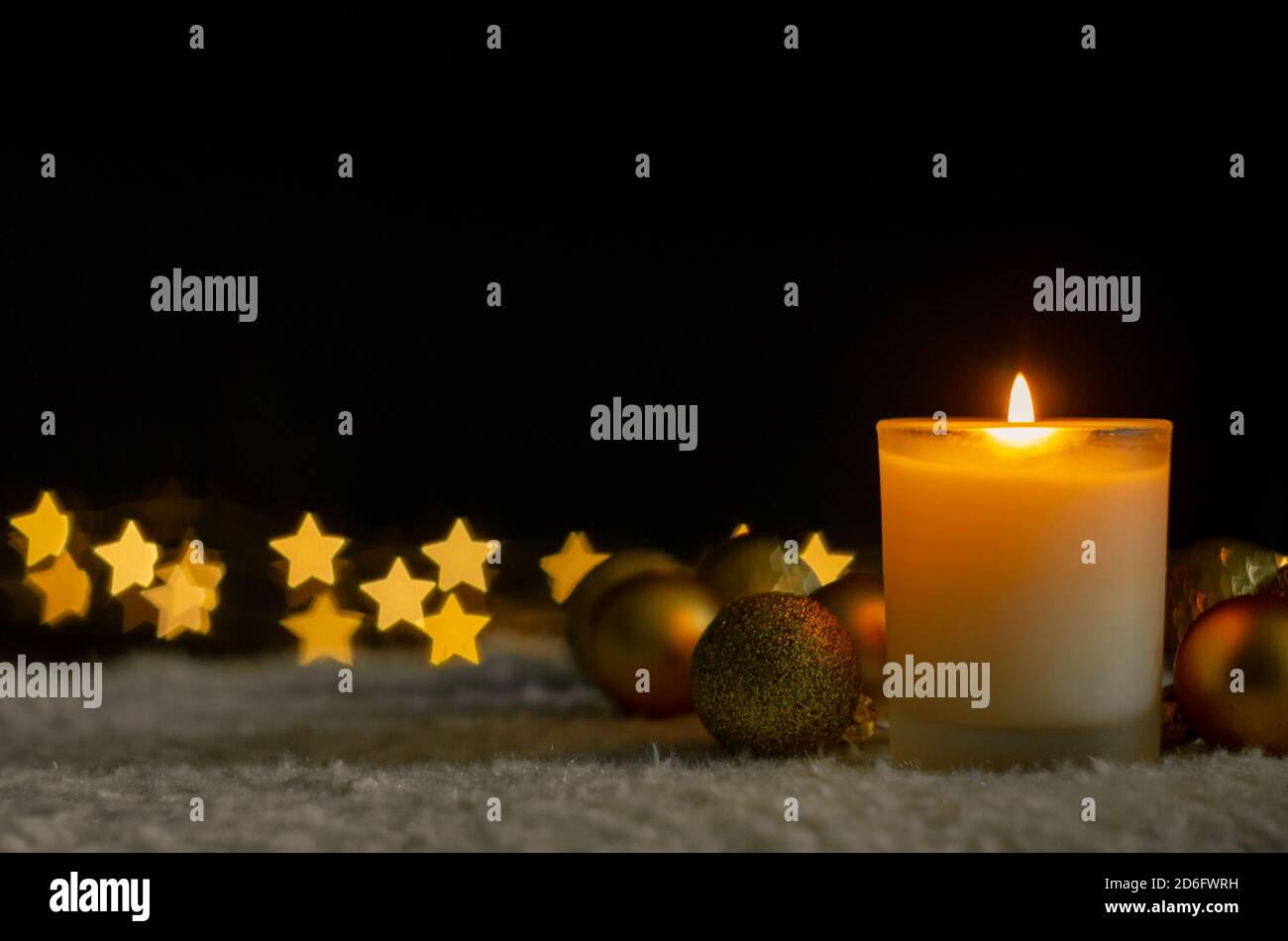 Luci a candela e ornamenti natalizi con luci bokeh a forma di stella dorata. Natale e Capodanno concetto. Foto Stock