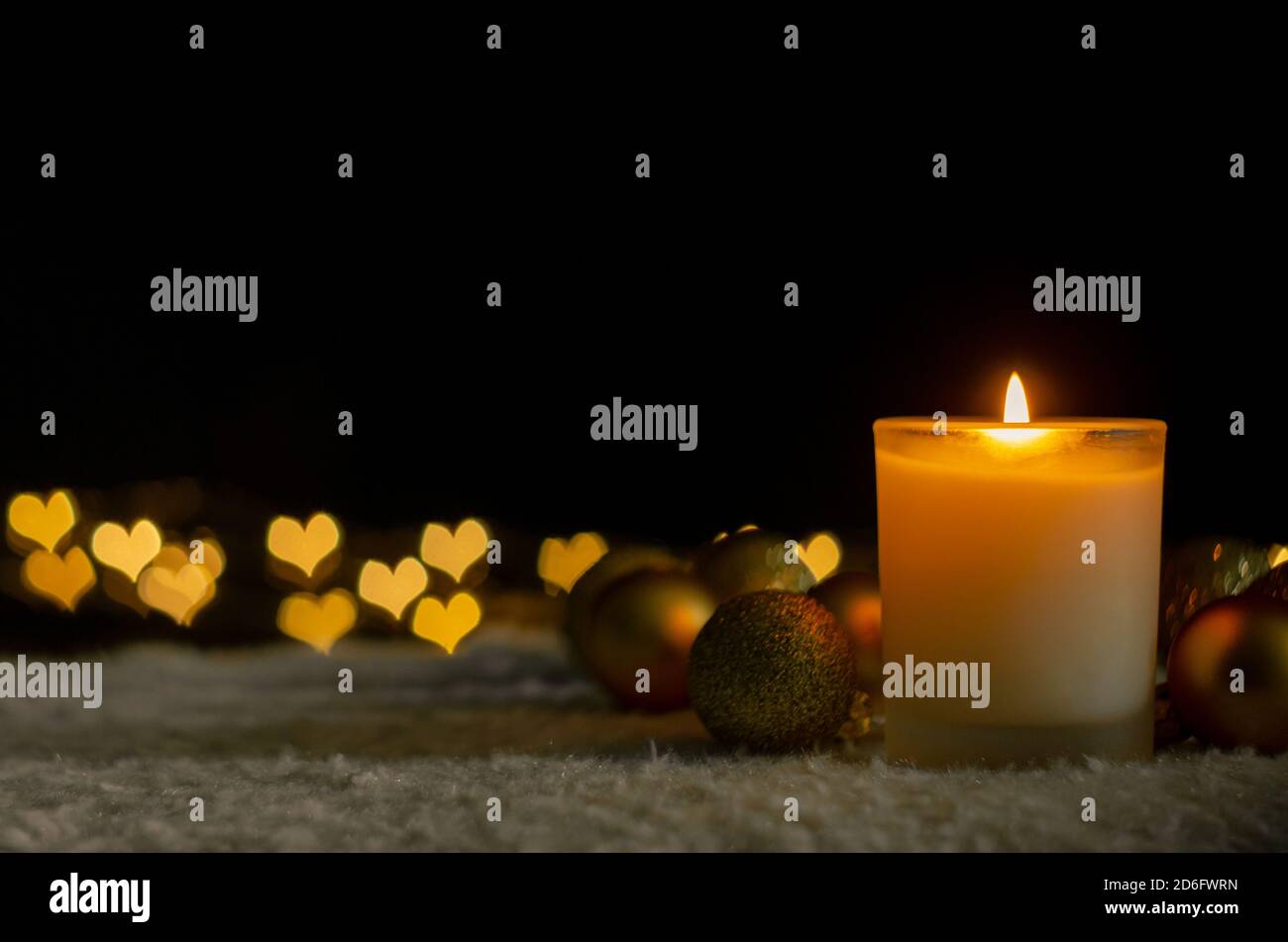 Luci a candela e ornamenti natalizi con luci dorate a forma di amore bokeh. Natale e Capodanno concetto. Foto Stock