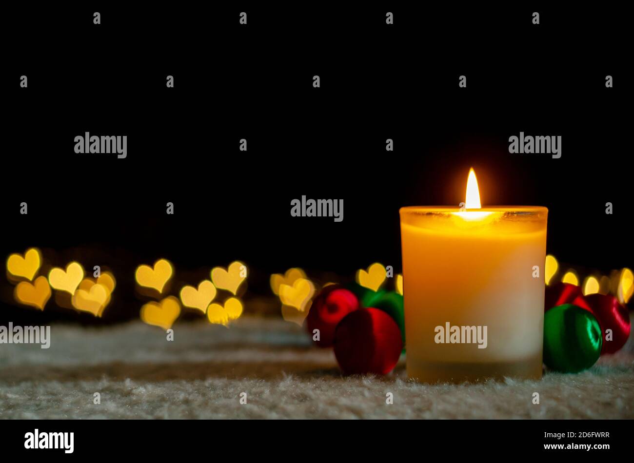 Luci a candela e ornamenti natalizi con luci dorate a forma di amore bokeh. Natale e Capodanno concetto. Foto Stock