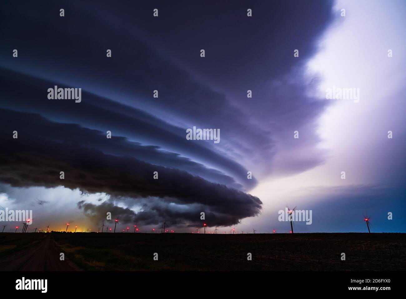 Nuvole di tempesta Supercell illuminate da un fulmine nel cielo notturno su una fattoria eolica a Spearville, Kansas Foto Stock