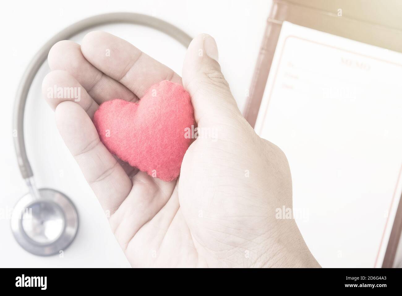cuore rosso in mano umana con tono drammatico Foto Stock