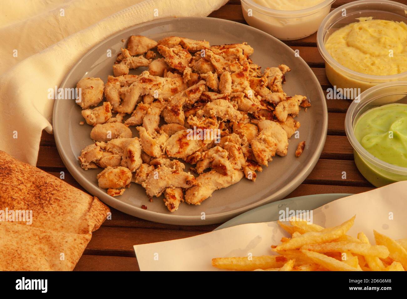 Piatto Shawarma di pollo con pane arabo e patatine fritte e salsa Sul tavolo Foto Stock