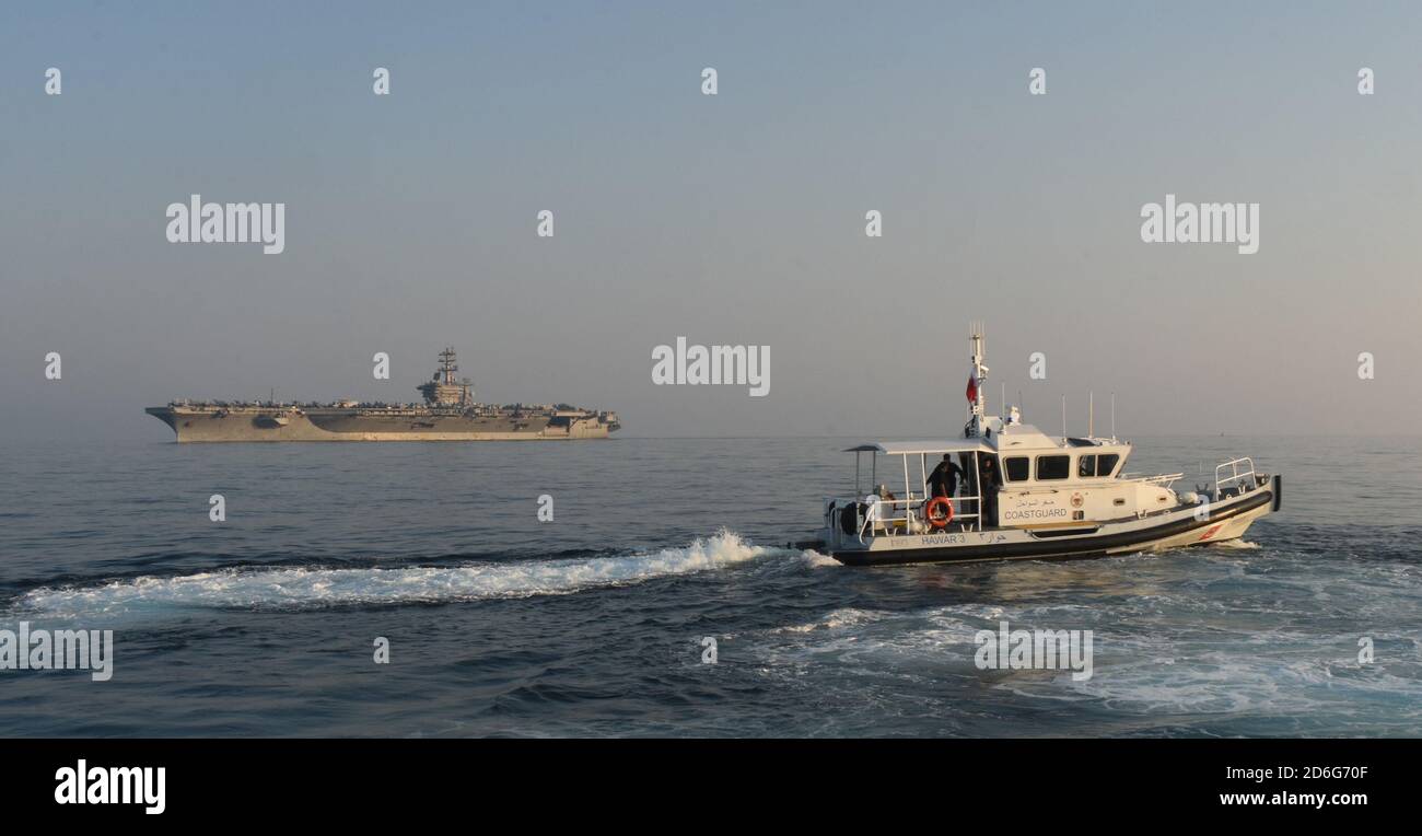 201007-A-FT904-1102 GOLFO DEL BAHRAIN (OTTOBRE 7, 2020) Bahraini Coast Guard Response boat Hawar 3, a destra, scorta la portaerei USS Nimitz (CVN 68) attraverso il Golfo del Bahrain, inbound ad una visita di manutenzione e logistica a Khalifa bin Salman Port, Bahrain, 7 ottobre. Nimitz, il fiore all'occhiello del Nimitz Carrier Strike Group, è schierato nell'area operativa della 5a flotta degli Stati Uniti, conducendo missioni a sostegno dell'OIR, e operazioni di sicurezza marittima a fianco di partner regionali e di coalizione. (STATI UNITI Esercito foto di staff Sgt. Timoteo Clegg) Foto Stock