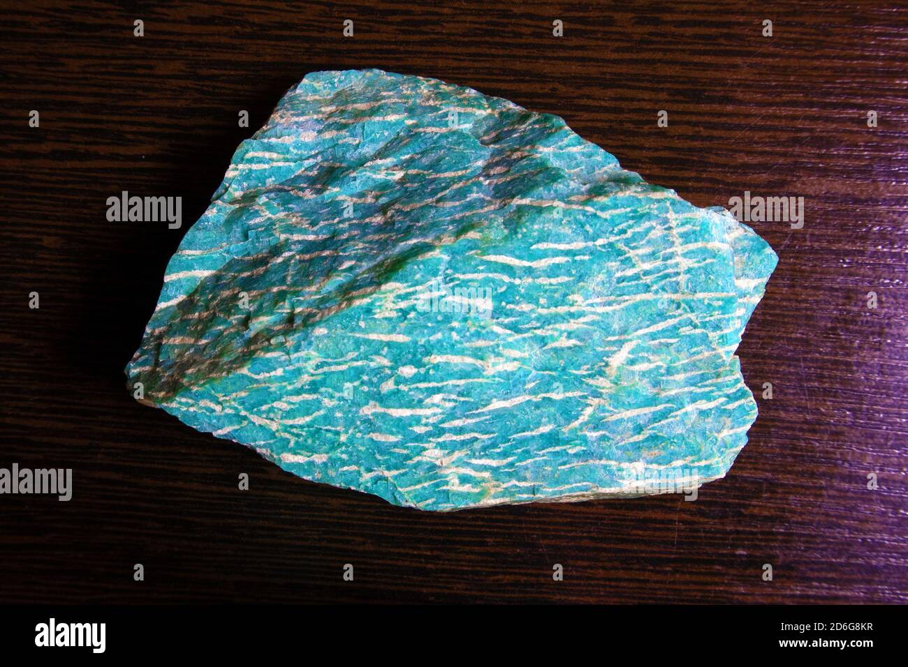 Grande pezzo di bella e luminosa amazonite minerale semi-recious sdraiato su una superficie di legno Foto Stock