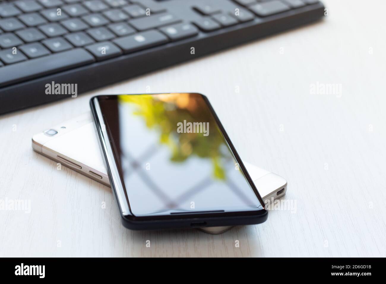 Telefoni cellulari uno sopra l'altro su un la batteria per la condivisione  del tavolo si ricarica in modalità wireless Foto stock - Alamy