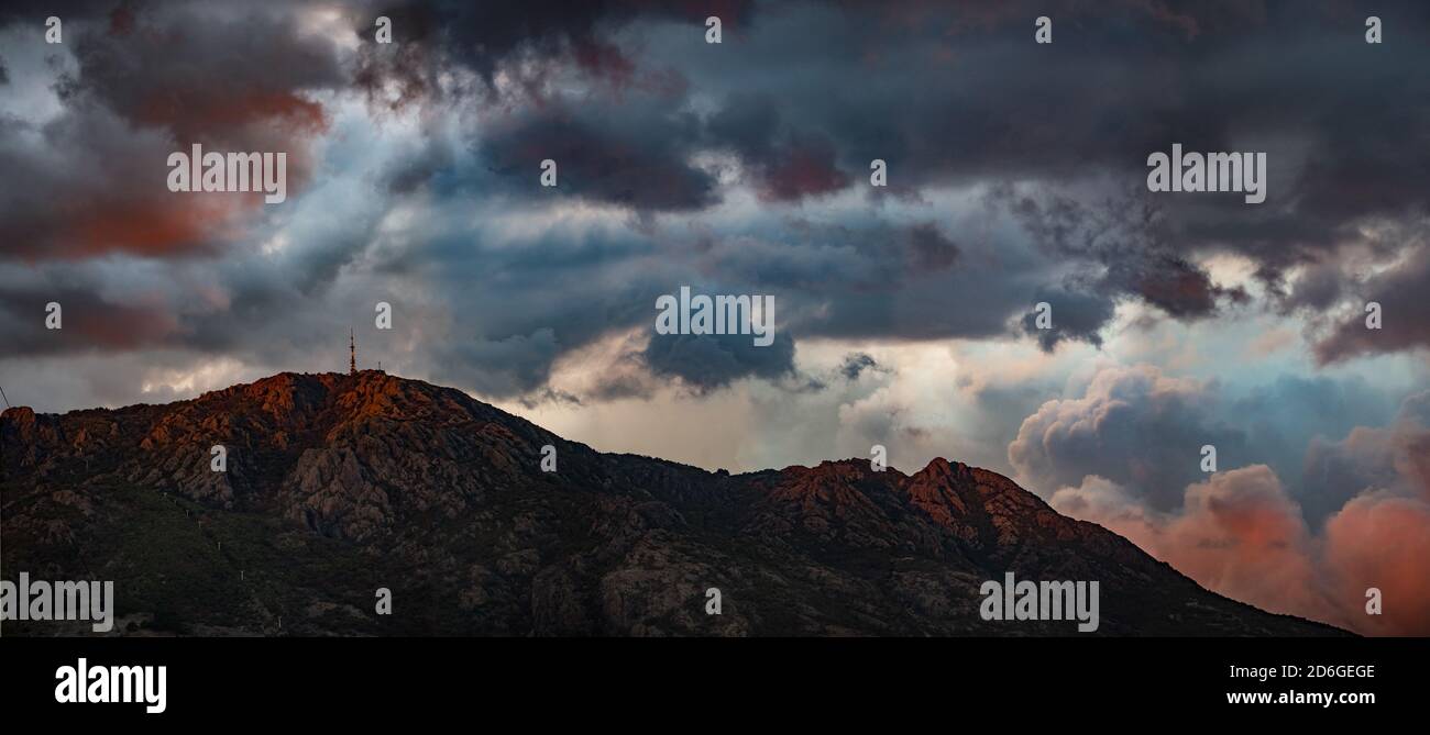 Paesaggio panoramico pomeridiano nuvoloso su una montagna in tonalità calde Foto Stock