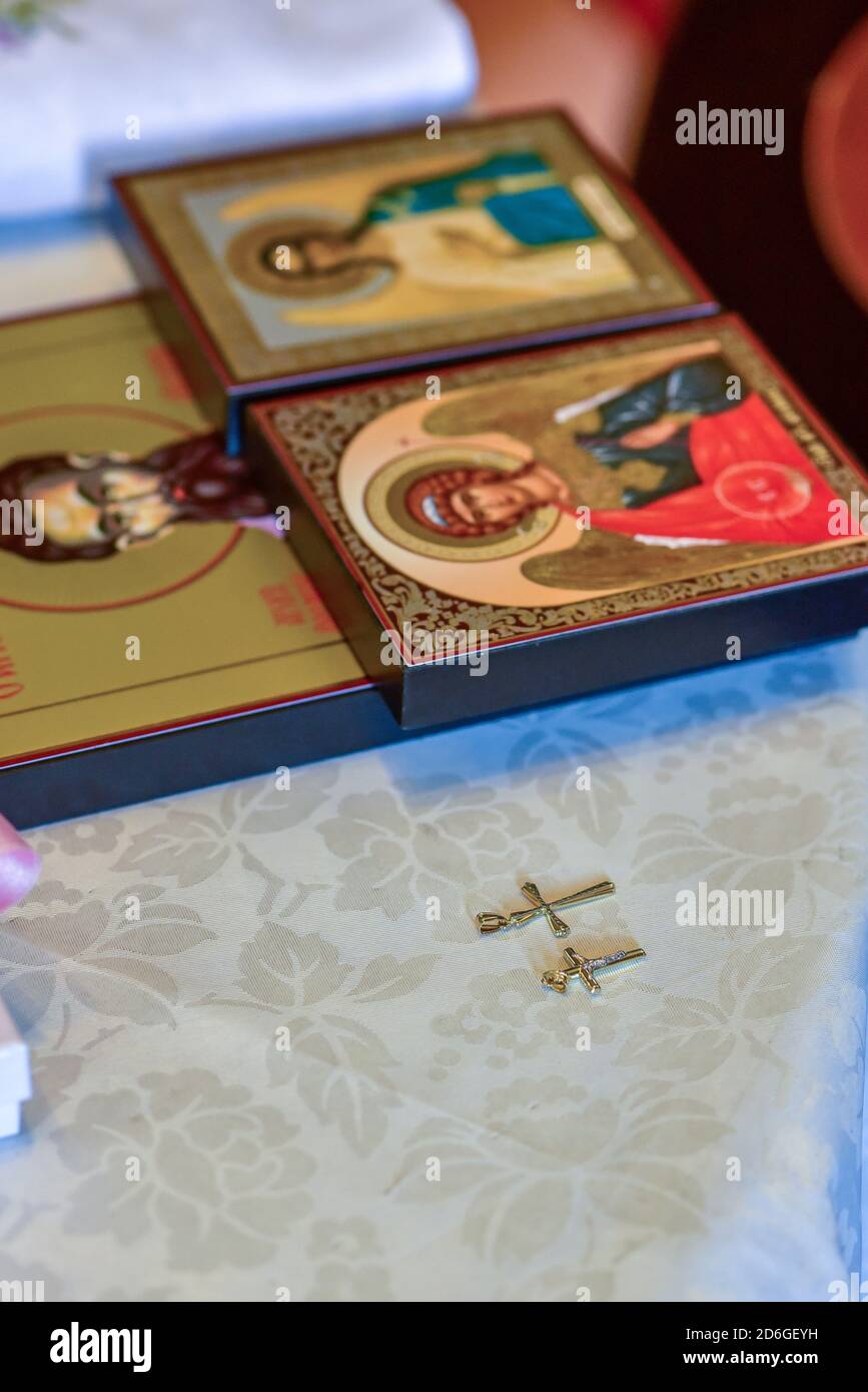 Battesimo ortodosso - icone e croci posati su un tavolo per la cerimonia Foto Stock