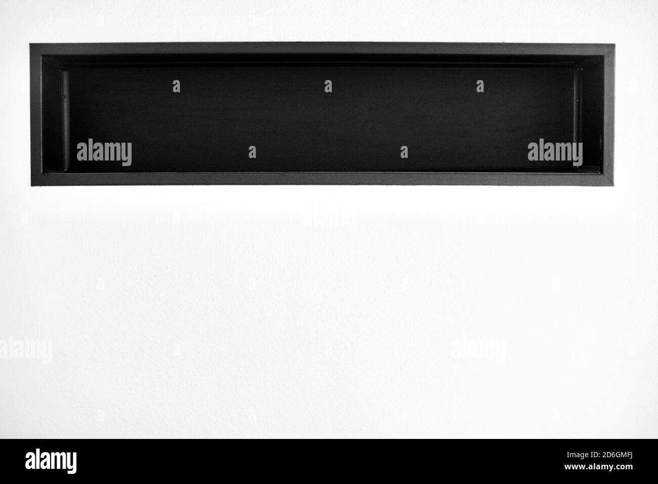 Ripiano nero integrato in una parete bianca Foto Stock