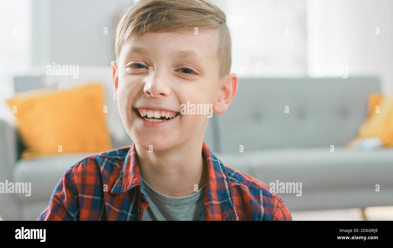 Ritratto dell'adorabile giovane ragazzo felice sorridente sulla macchina fotografica. In background offuscato Sunny Room. Foto Stock