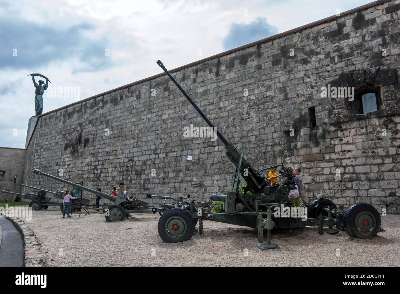 I bambini ispezionano l'artiglieria militare allestita presso la Cittadella (Fortezza) sulla collina Gellert a Budapest in Ungheria. Foto Stock