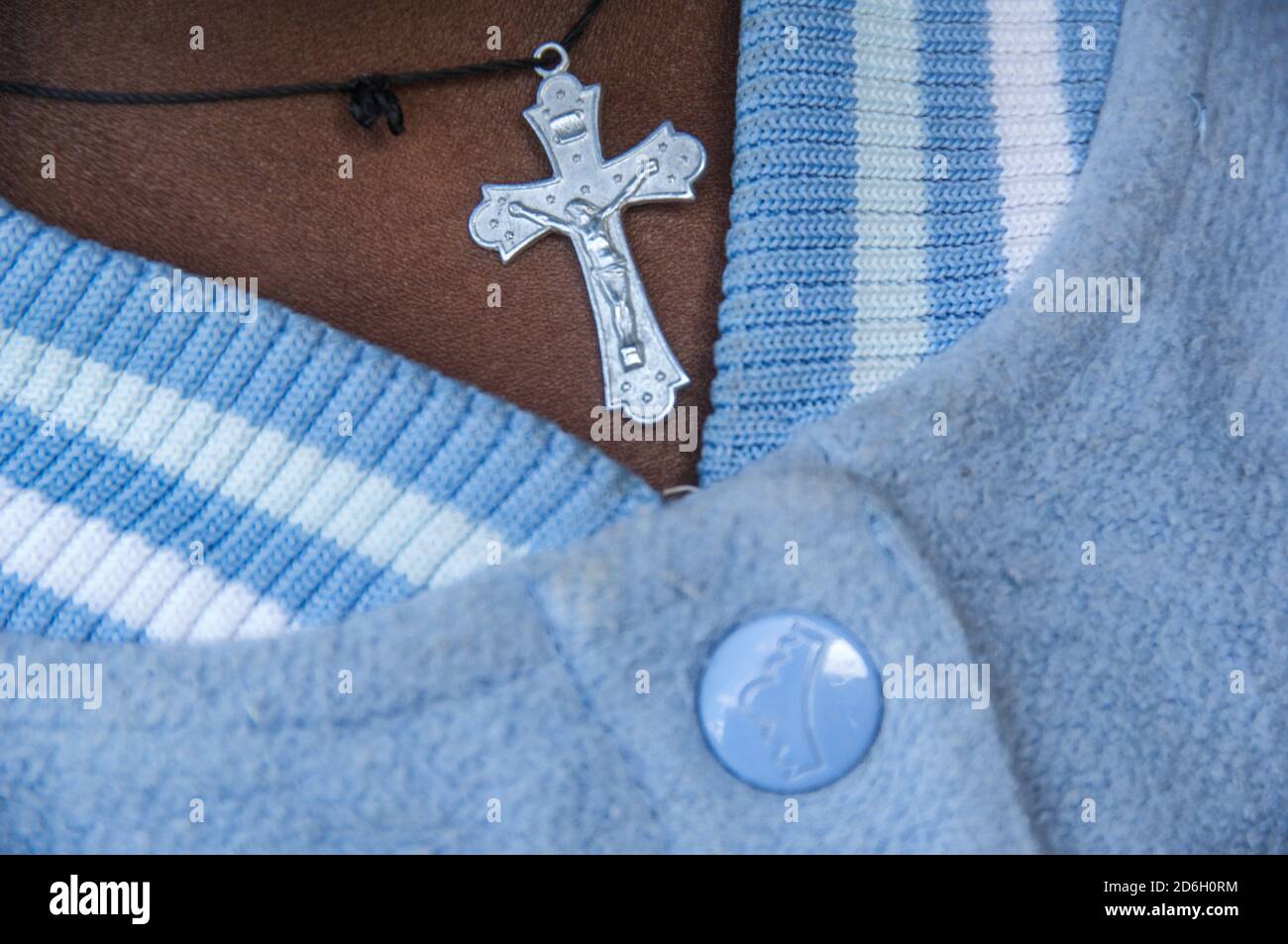 Primo piano di un crocifisso indossato su una corda intorno al collo di un bambino ruandese Foto Stock