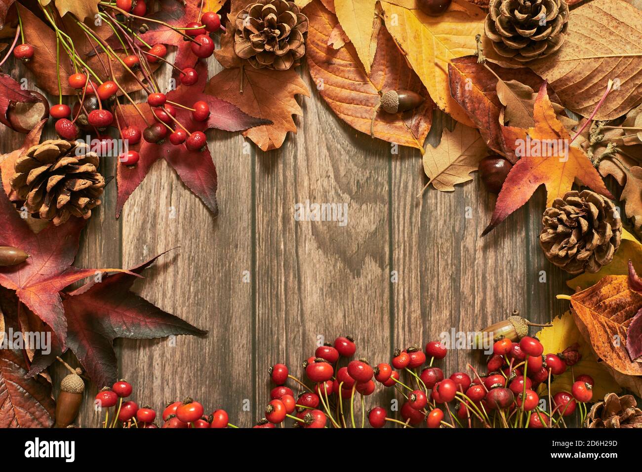 Sfondo colorato con foglie autunnali e decorazioni stagionali in legno superficie Foto Stock