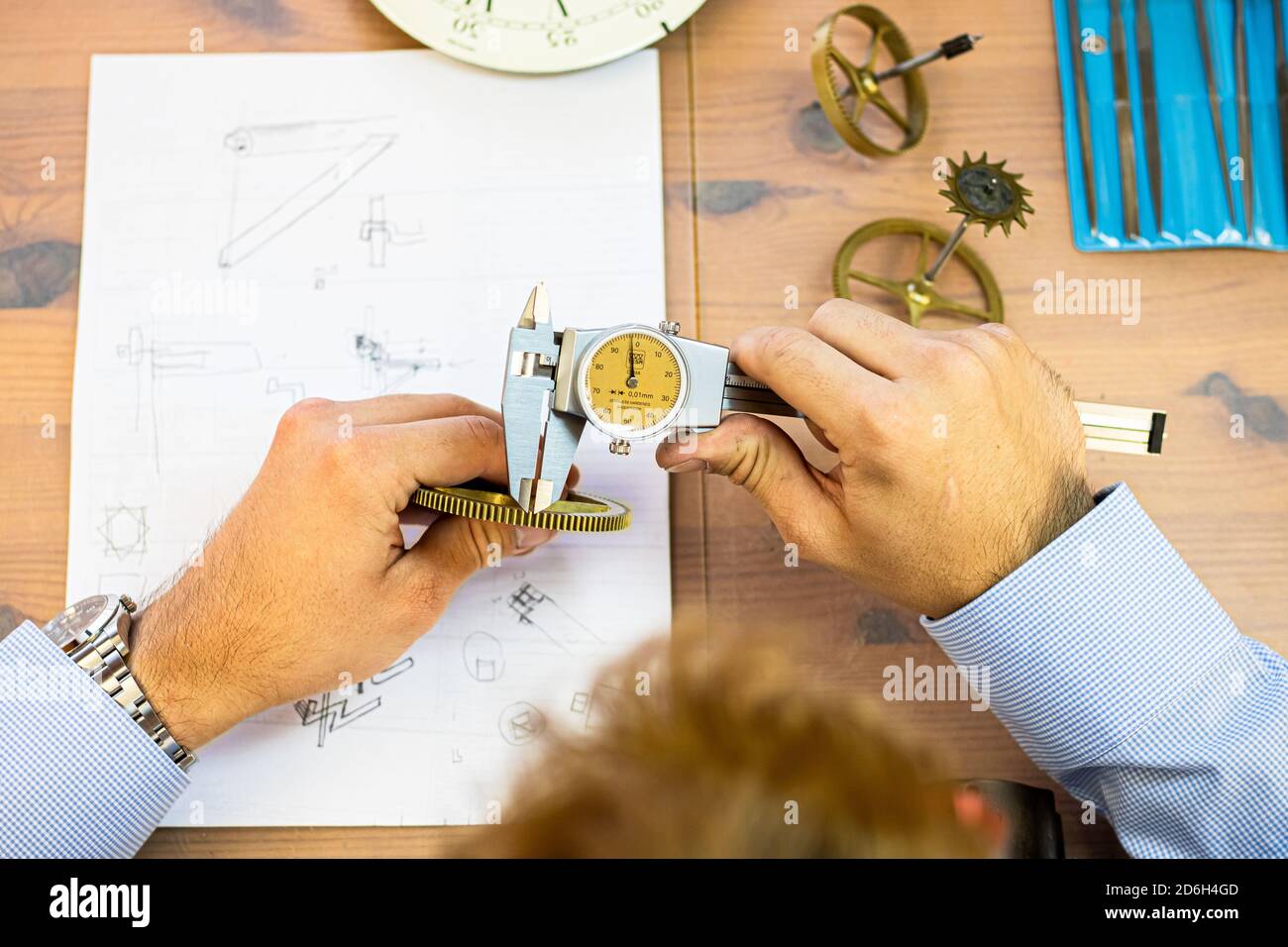 giovane uomo che monta orologio meccanico. produzione orologi. mani mans Foto Stock