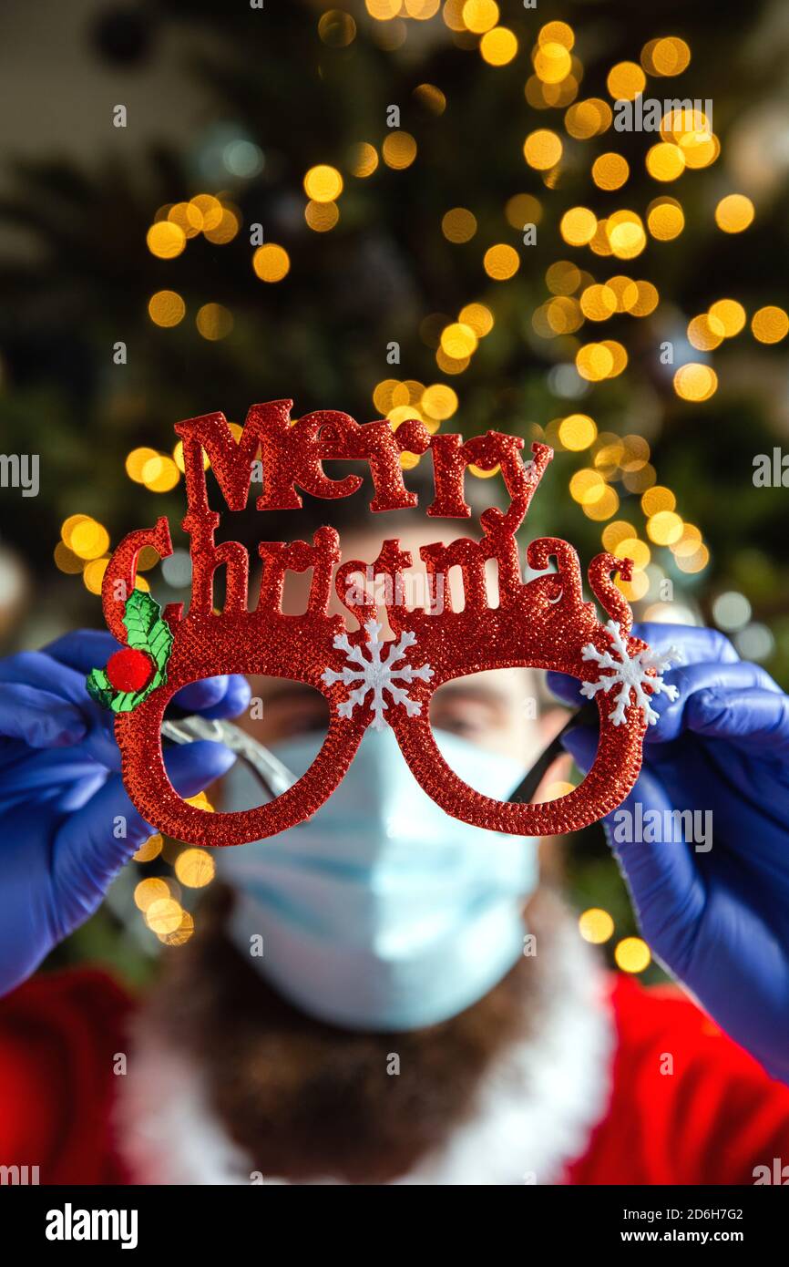 Occhiali da uomo con Merry Christmas e maschera di sicurezza protettiva e guanti per Coronavirus, Covid-19 e Holiday Concept Foto Stock