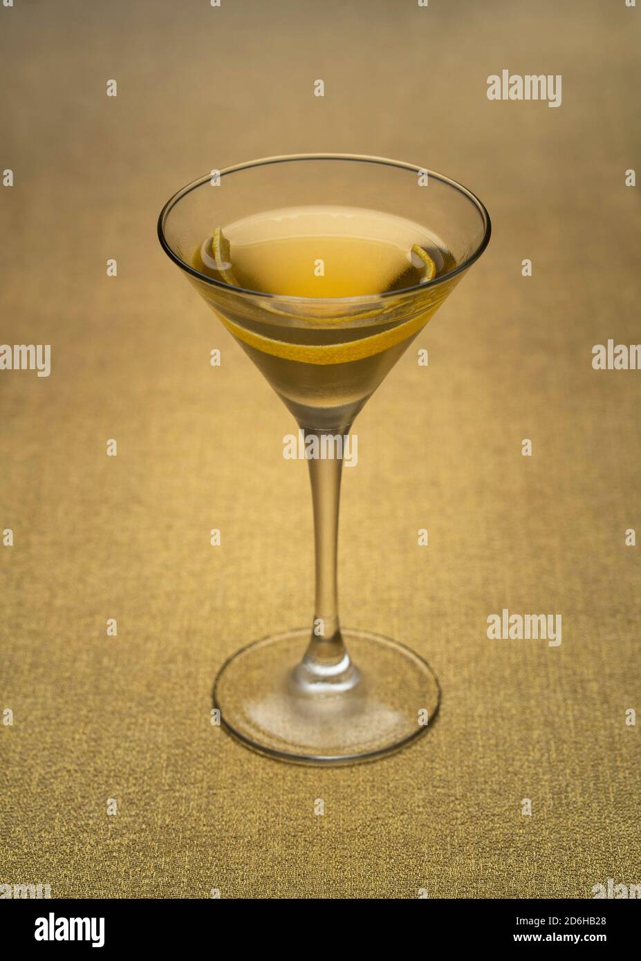 Cocktail alla vodka Martini con tocco di limone al chiuso su tessuto dorato Foto Stock