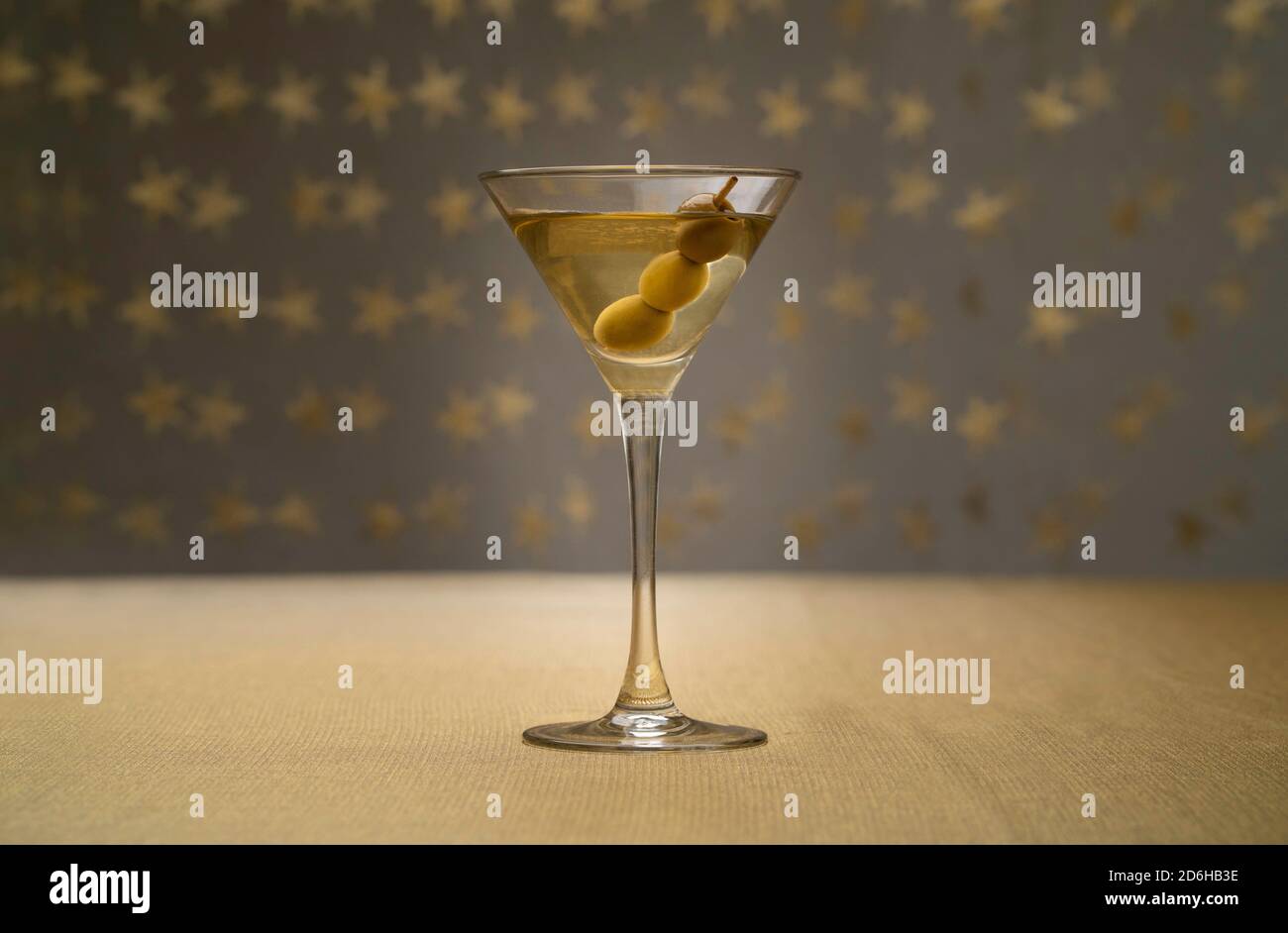 vodka martini con olive all'interno su tessuto dorato con stellato sfondo Foto Stock