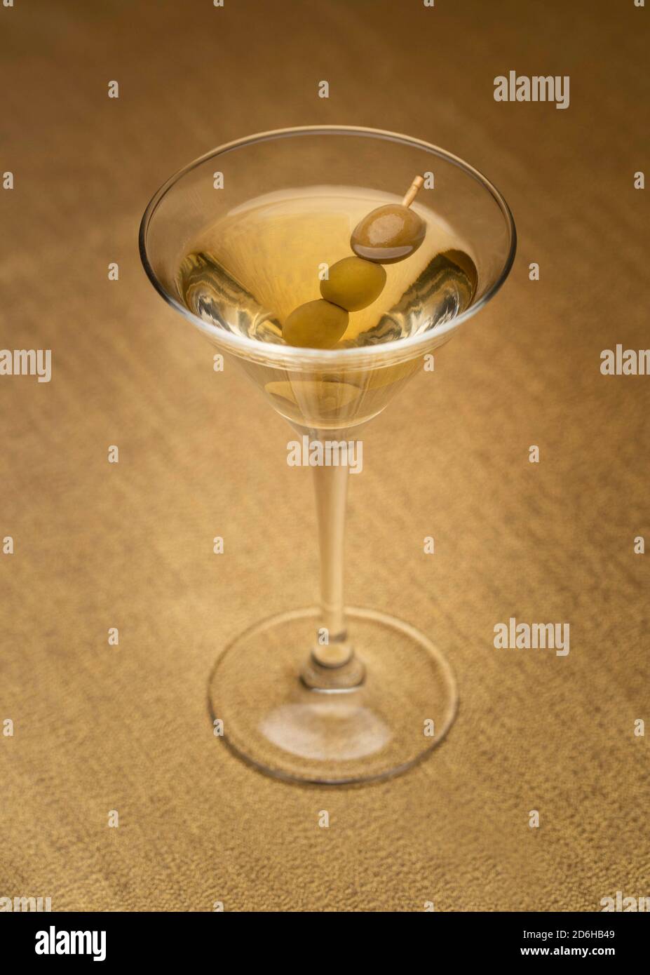 Cocktail di vodka martini con olive su tessuto dorato fotografato dall'alto Foto Stock