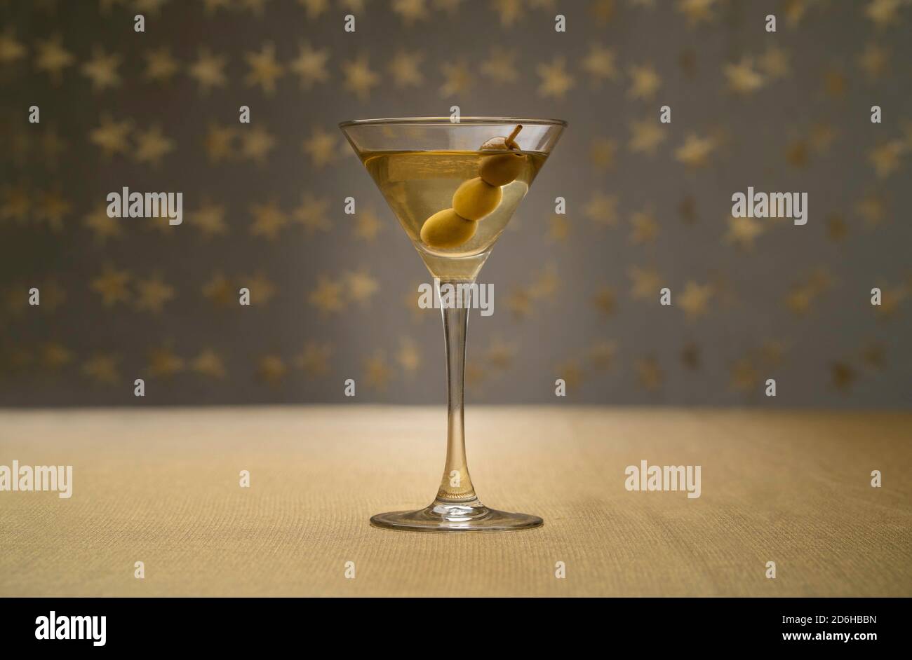 Cocktail alla vodka martini con tre olive su tessuto dorato con sfondo stellato Foto Stock