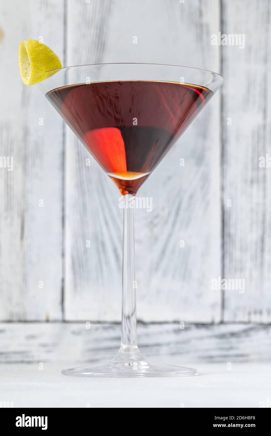Bicchiere di cocktail Martinez guarnito con scorza di limone Foto Stock