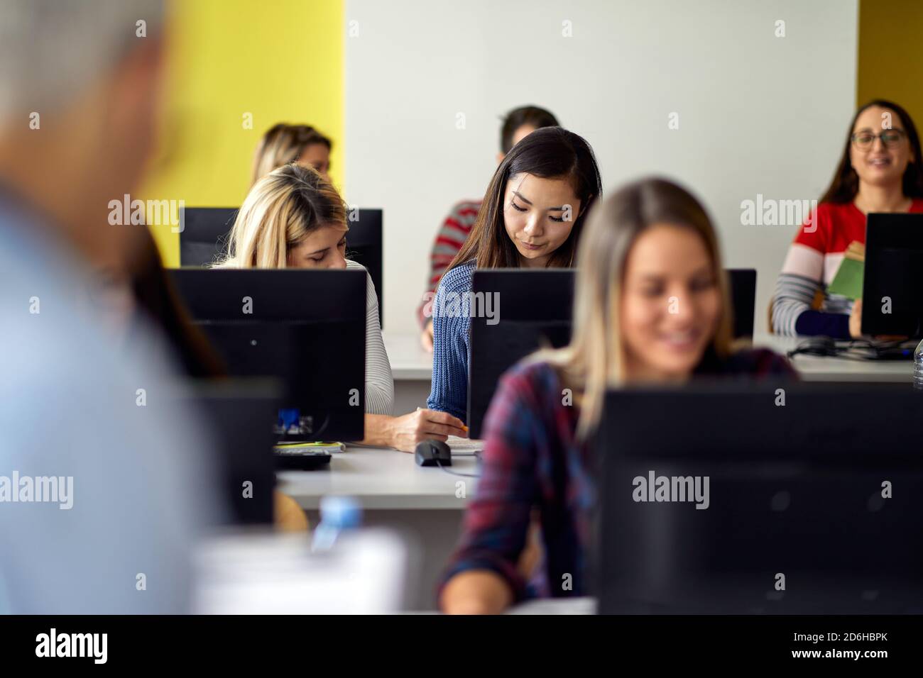 Atmosfera di lavoro alla lezione informatica nell'aula informatica universitaria. I giovani intelligenti studiano all'università. Istruzione, università, università Foto Stock