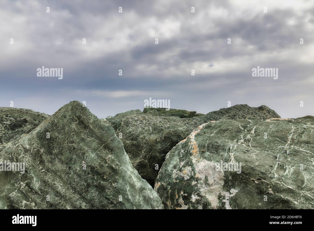 Pietre giganti. Copia spazio. Pietre naturali che proteggono le mura del porto. Cielo sullo sfondo. Immagine stock. Foto Stock