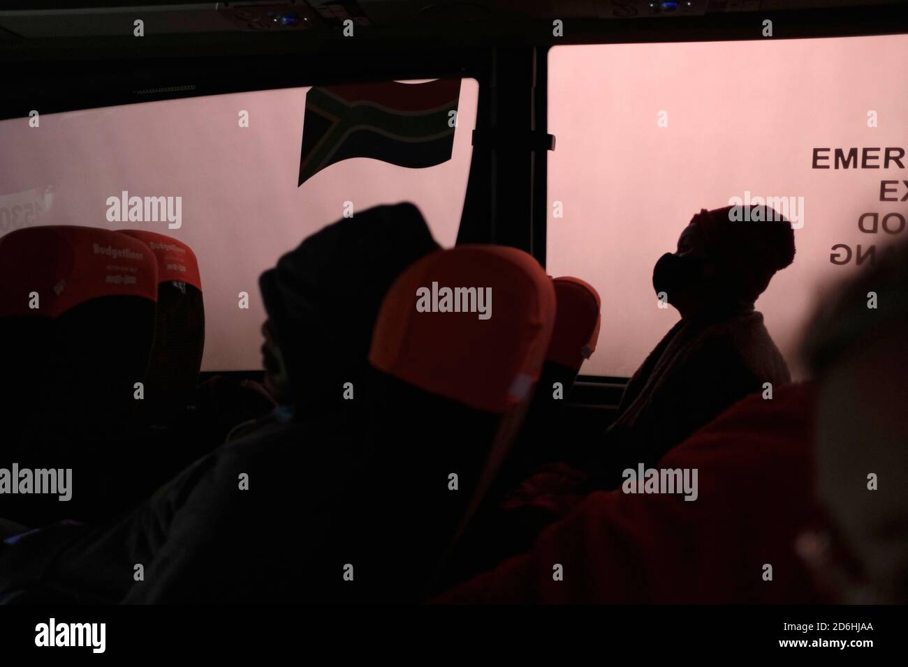 I passeggeri che indossano maschere durante il viaggio su un autobus (pullman) in Sud Africa durante il periodo pandemico di Covid-19. Foto Stock