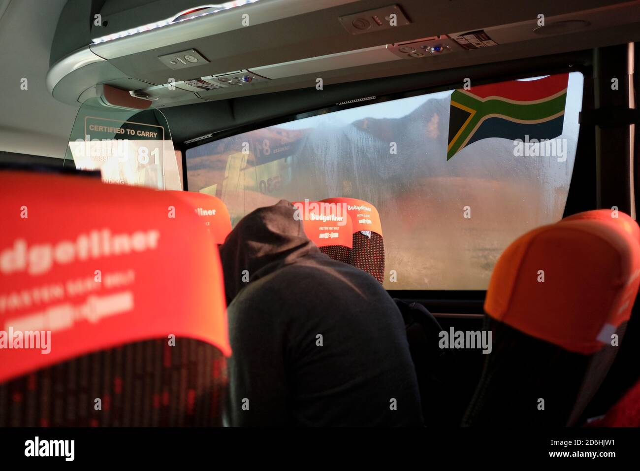 I passeggeri che indossano maschere durante il viaggio su un autobus (pullman) in Sud Africa durante il periodo pandemico di Covid-19. Foto Stock