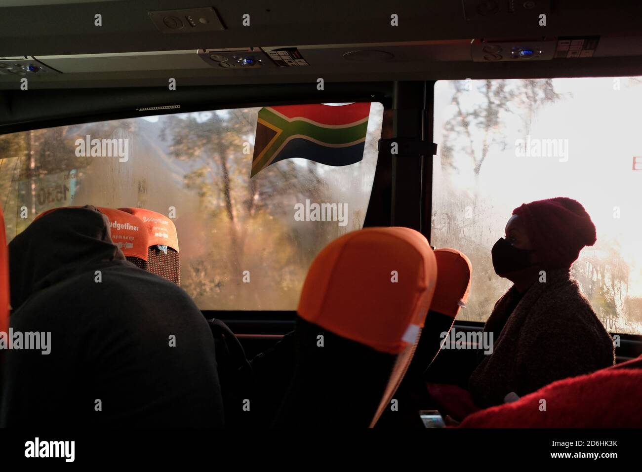 I passeggeri che indossano maschere durante il viaggio su un autobus (pullman) in Sud Africa durante il periodo pandemico di Covid-19. Foto Stock